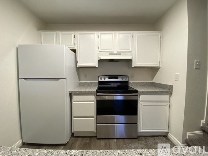 A kitchen with white appliances and cabinets.