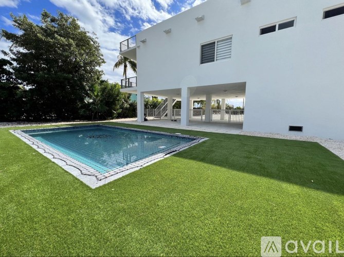 A white house with a pool in the backyard.