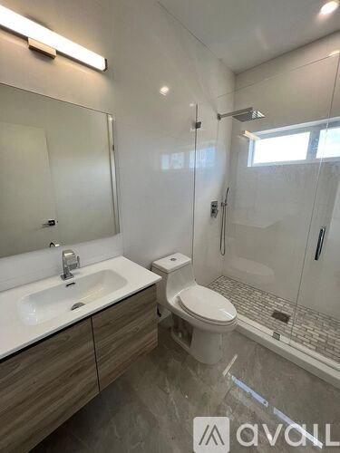 A bathroom with a sink, toilet, and shower.