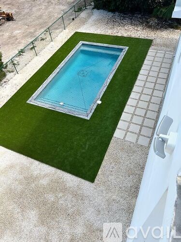 A small rectangular pool with a green lawn around it.