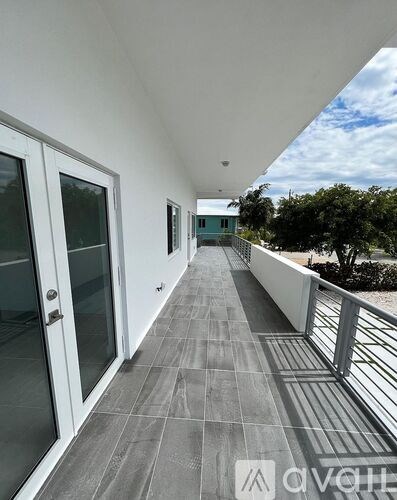 A balcony with a metal railing and tiled floor.