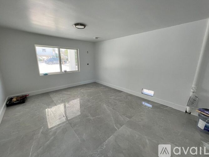 A room with grey marble flooring and white walls.