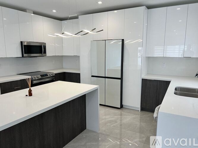 A modern kitchen with white cabinets and a central island.
