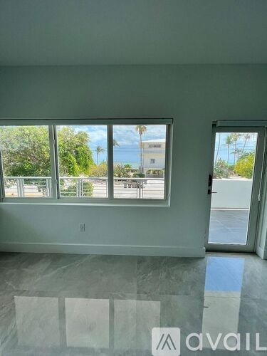 A room with a large window overlooking a parking lot.