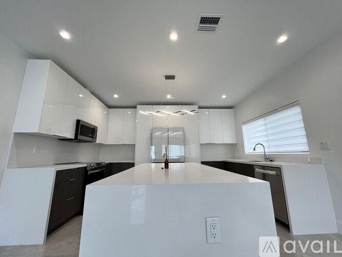 A modern kitchen with white cabinets and a large island.