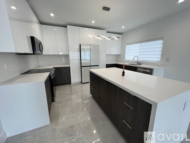 A modern kitchen with white and black cabinets and a central island.