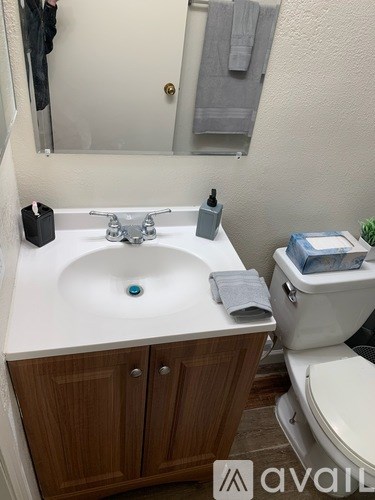 A bathroom with a white sink and a toilet.
