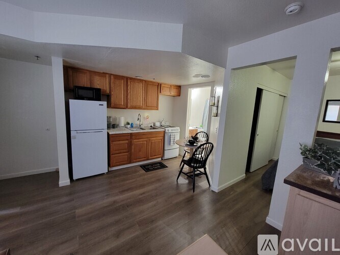 A kitchen with wooden cabinets and a white fridge.
