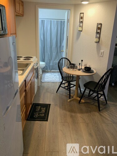 A kitchen with a table and chairs in front of a window.