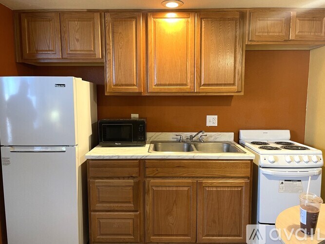 A kitchen with brown cabinets and white appliances.