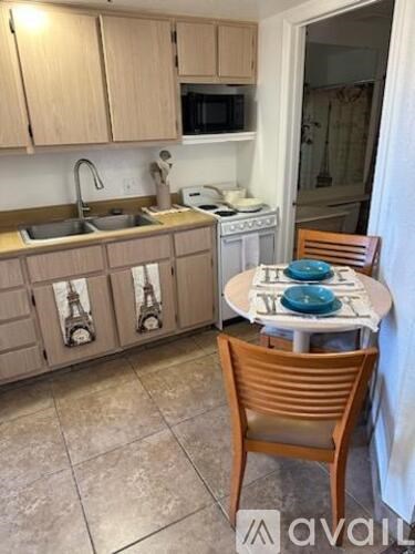 A kitchen with a table and chairs.