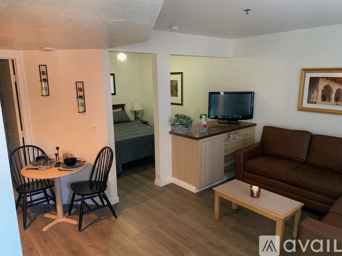 A living room with a couch, a table, and a television.
