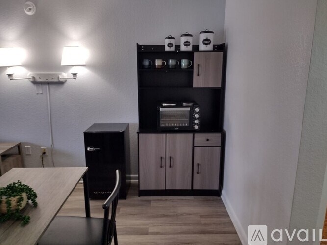 A kitchen area with a black fridge, a black cabinet, and a black oven.