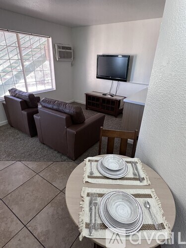 A living room with a couch, chair, and television.