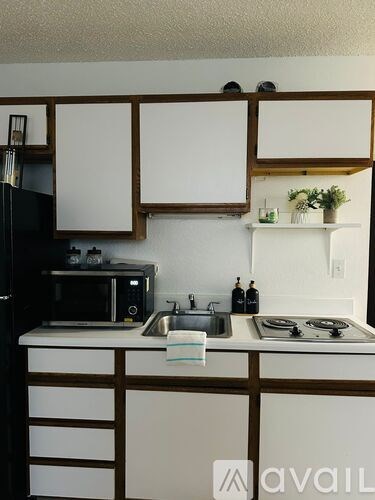 A kitchen with white countertops and wooden cabinets.