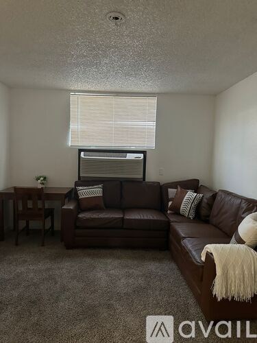 A living room with a brown couch and a small table.