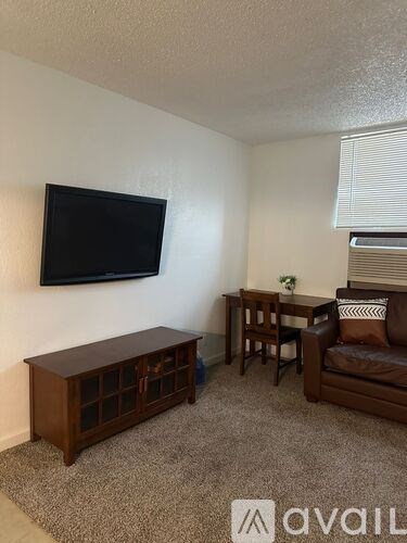 A living room with a flat screen TV mounted on the wall.