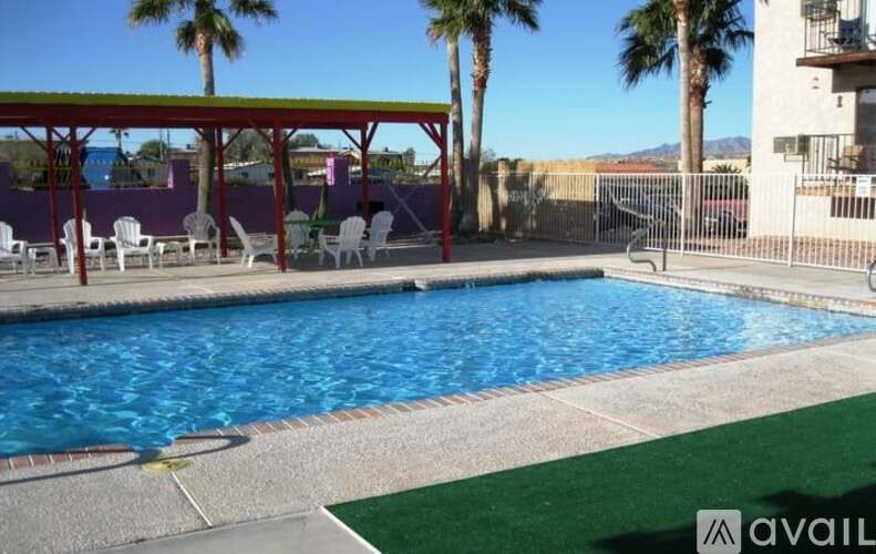 A pool with a red roof and white chairs.