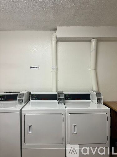 A wall-mounted washing machine with a white top and a white door.