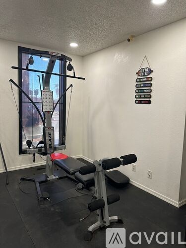 A gym room with a weight bench and a mirror.