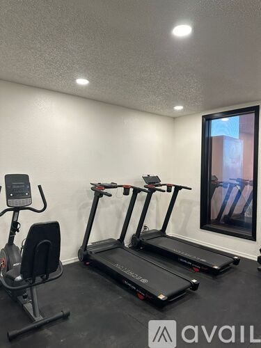 A room with a treadmill and a stationary bike.