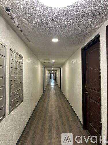 A long hallway with a row of mailboxes on the wall.