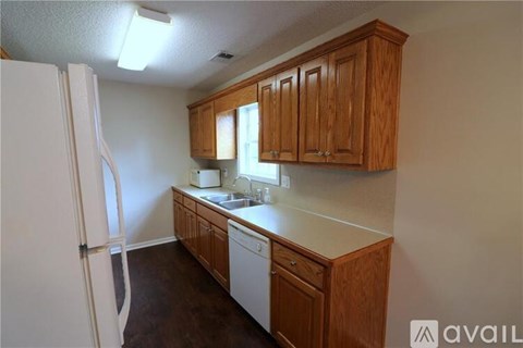 A kitchen with wooden cabinets and a white refrigerator.