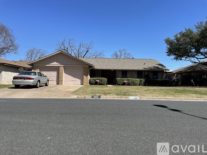 A house with a car parked in front of it.