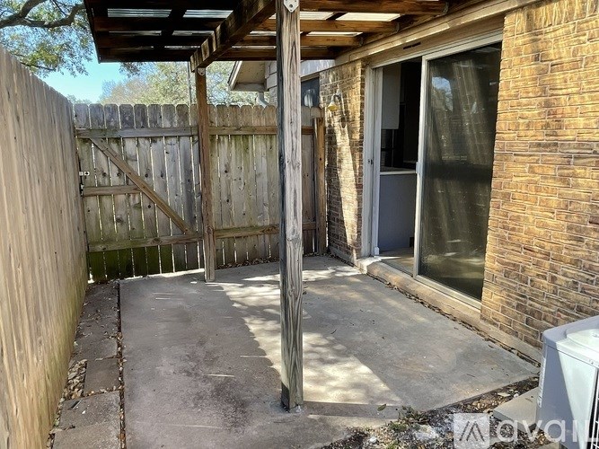 A backyard with a wooden fence and a concrete patio.