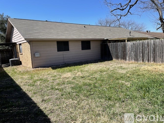 A house with a grey roof and a wooden fence.