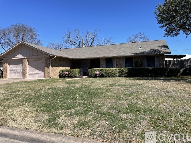 A house with a brown roof and a grey garage door.
