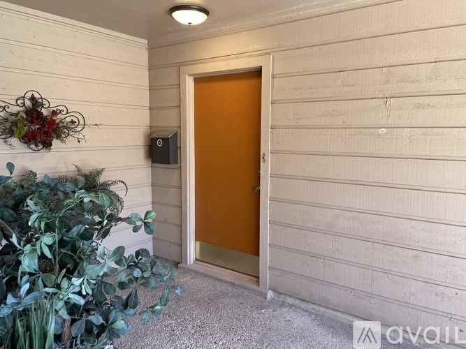 A door with a brown frame is in a room with white walls.