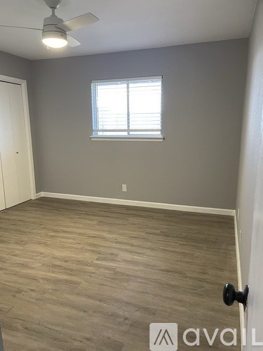 A room with a ceiling fan and a window with blinds.