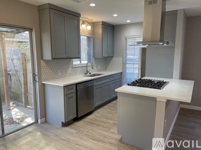 A kitchen with a white countertop and black appliances.