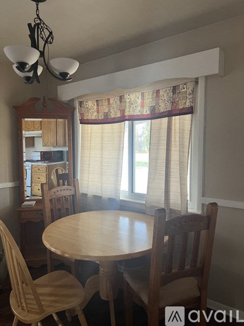 A dining room with a table and chairs.