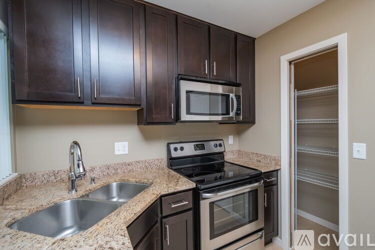 A kitchen with brown cabinets and a black stove top oven.