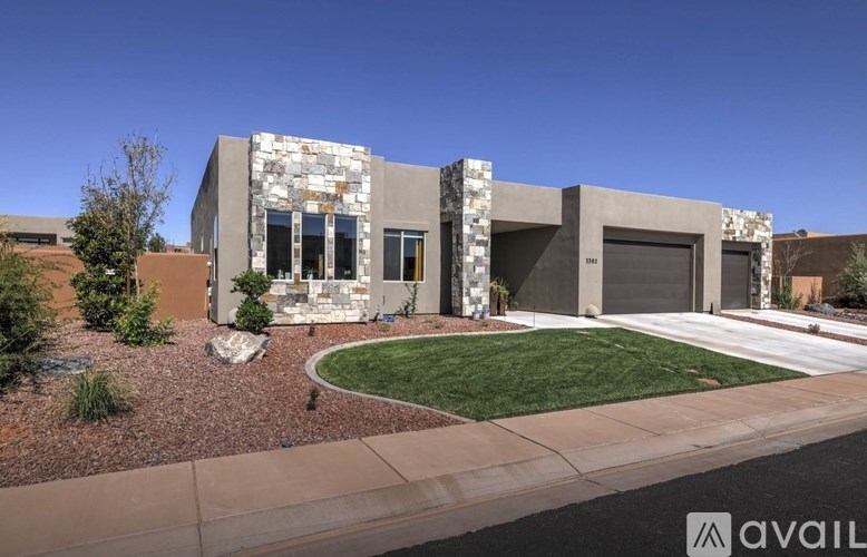 A modern house with a stone facade and a large front yard.