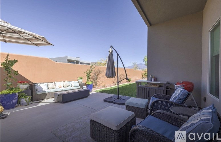 A patio with a white couch, a table, and a red chair.