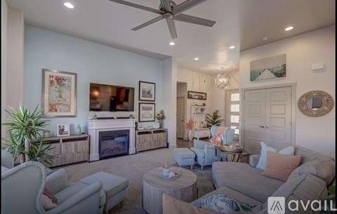 A living room with a grey couch and a fireplace.