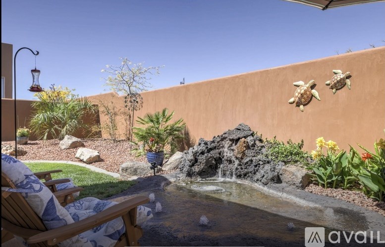 A garden with a waterfall and a wall with turtle decorations.