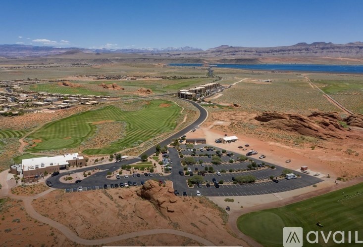 A golf course with a clubhouse and a lake in the background.
