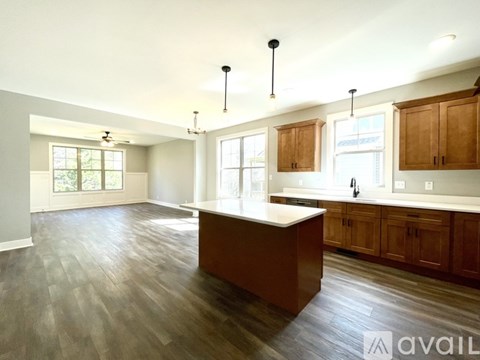 A kitchen with wooden cabinets and a large island.