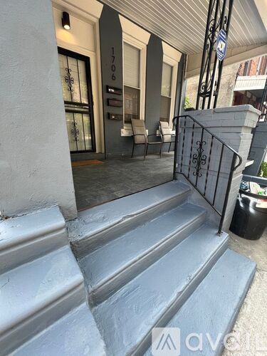 A set of stairs leading to a door with a sign above it.