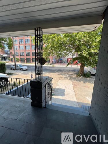 A view from a balcony looking out at a street with cars and buildings.