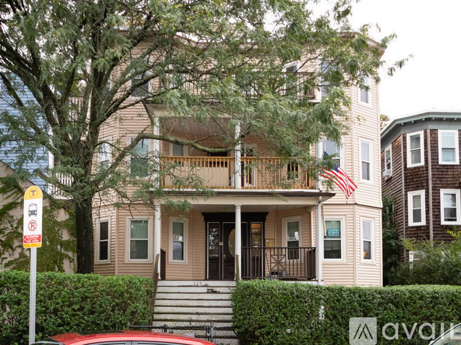 A house with a balcony and an American flag hanging on it.