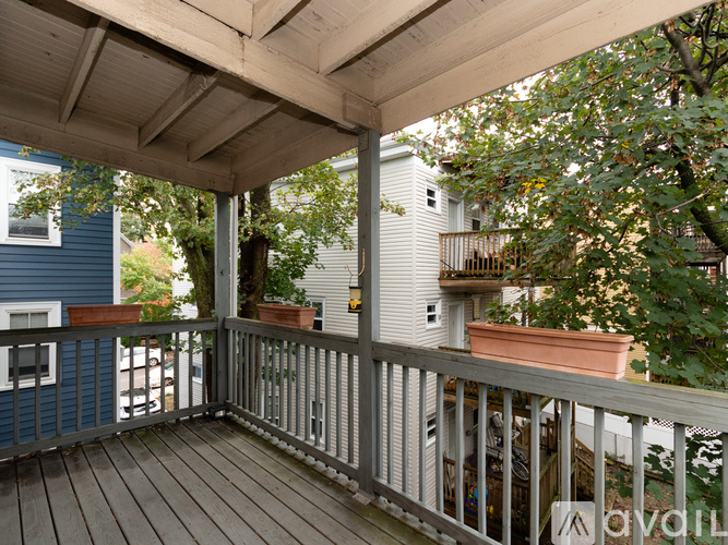 A wooden deck with a white railing and a potted plant on it.