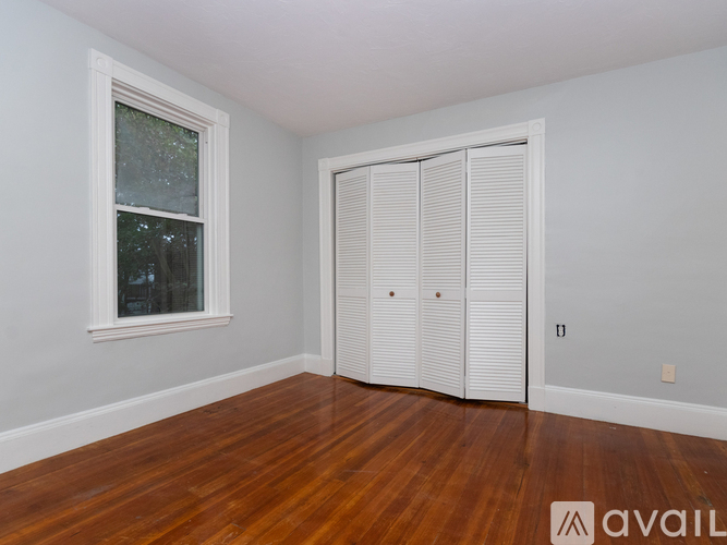 A room with a wooden floor and a white closet.