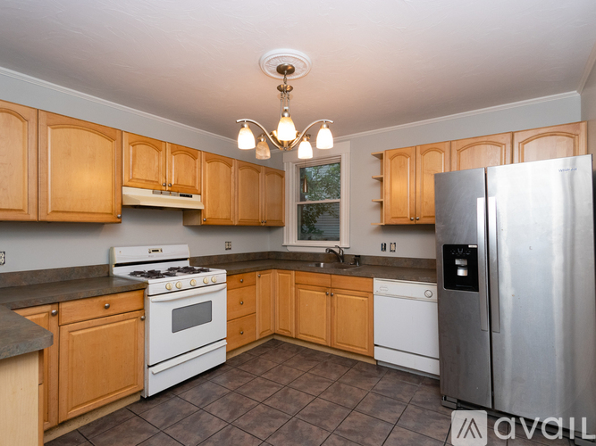 A kitchen with wooden cabinets and a stainless steel refrigerator.