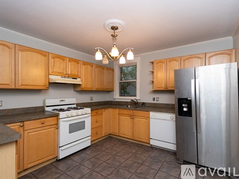A kitchen with wooden cabinets and a stainless steel refrigerator.