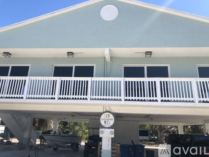 A white building with a balcony and a sign that says "Open".